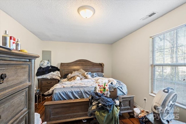 bedroom featuring wood-type flooring and a textured ceiling