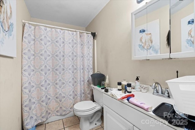 bathroom with toilet, vanity, and tile patterned floors