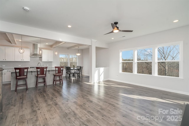 living room with ceiling fan, sink, dark hardwood / wood-style floors, and beamed ceiling