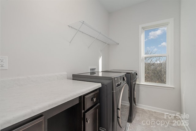 laundry area with a healthy amount of sunlight, washer and dryer, and light tile patterned floors