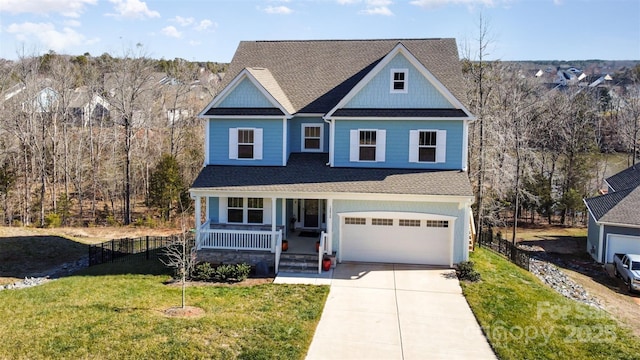 view of front of property featuring a garage, a front yard, and covered porch