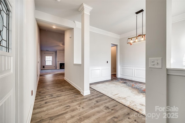 foyer featuring wood-type flooring, ornamental molding, and a notable chandelier