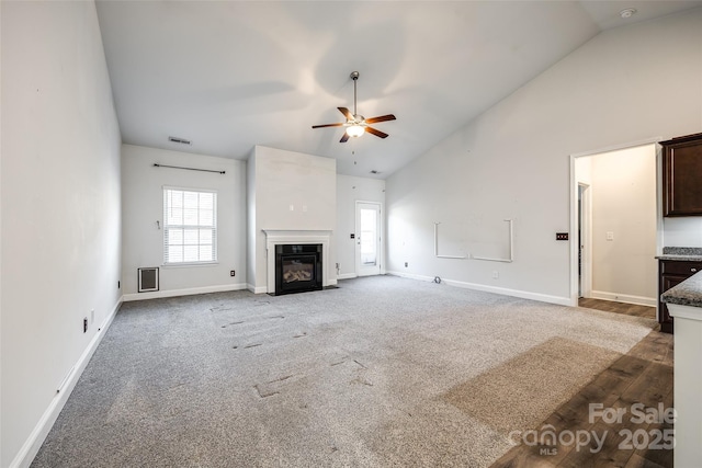 unfurnished living room featuring high vaulted ceiling, ceiling fan, and carpet