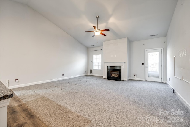 unfurnished living room with ceiling fan, high vaulted ceiling, and carpet