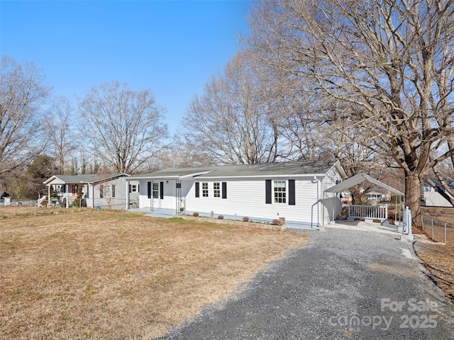 ranch-style home featuring a front lawn and a carport