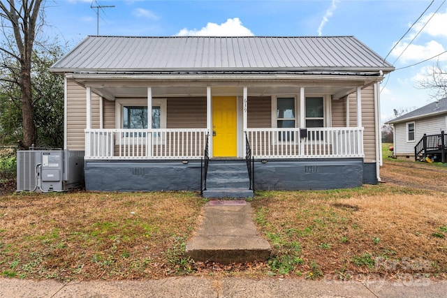 bungalow featuring covered porch, central AC, and a front lawn