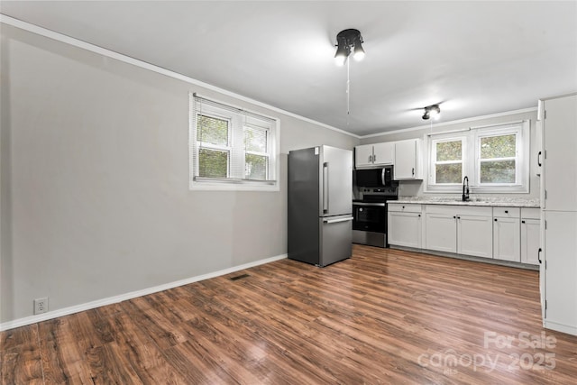 kitchen featuring hardwood / wood-style flooring, sink, white cabinetry, and stainless steel appliances