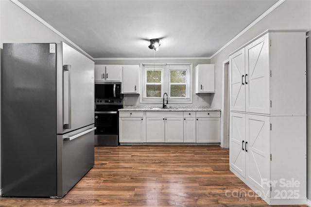 kitchen with sink, stainless steel appliances, dark hardwood / wood-style flooring, white cabinets, and ornamental molding