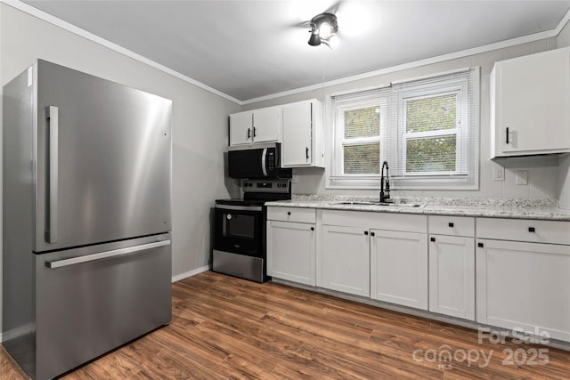 kitchen with light stone counters, stainless steel appliances, dark wood-type flooring, sink, and white cabinets