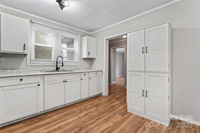 kitchen with white cabinets, wood-type flooring, and sink