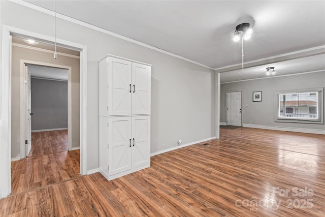 empty room featuring hardwood / wood-style floors and ornamental molding