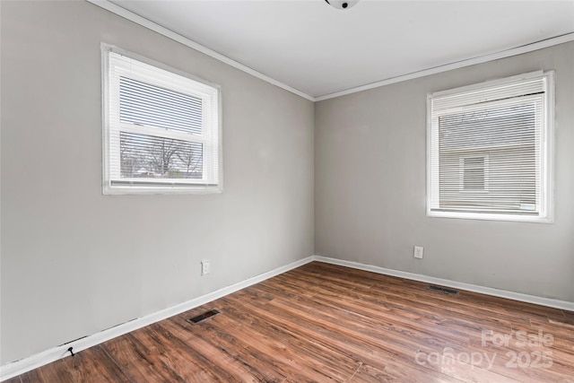 spare room with dark hardwood / wood-style flooring and crown molding