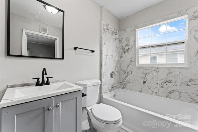 full bathroom featuring vanity, tiled shower / bath combo, and toilet