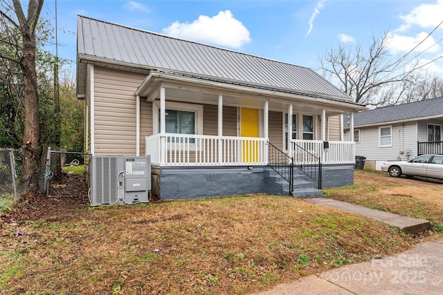 bungalow featuring central AC unit, a porch, and a front yard