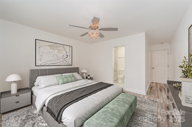 bedroom featuring ceiling fan, connected bathroom, and hardwood / wood-style flooring