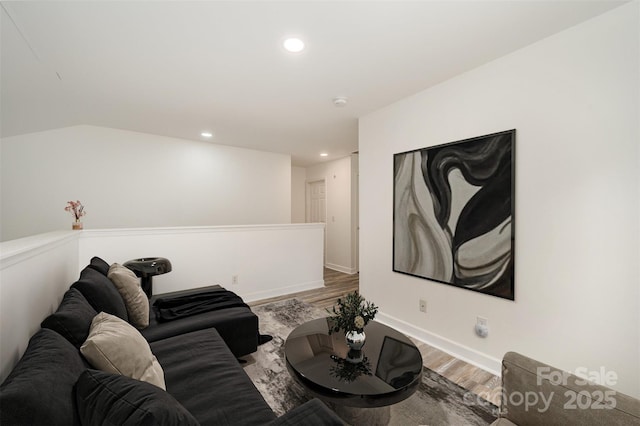 living room featuring vaulted ceiling and hardwood / wood-style flooring