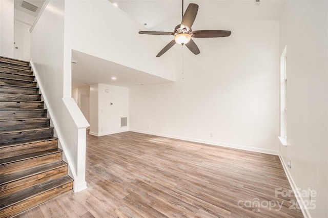 unfurnished living room featuring high vaulted ceiling, ceiling fan, and light hardwood / wood-style floors