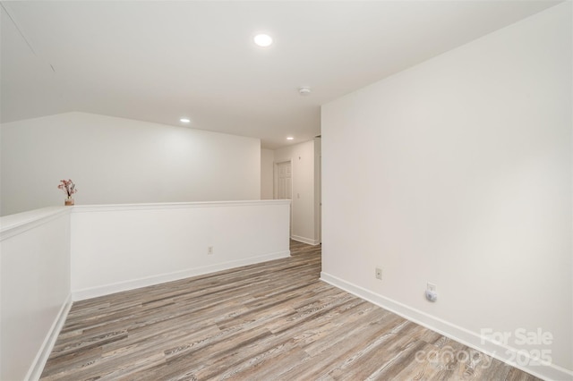 empty room featuring lofted ceiling and hardwood / wood-style floors