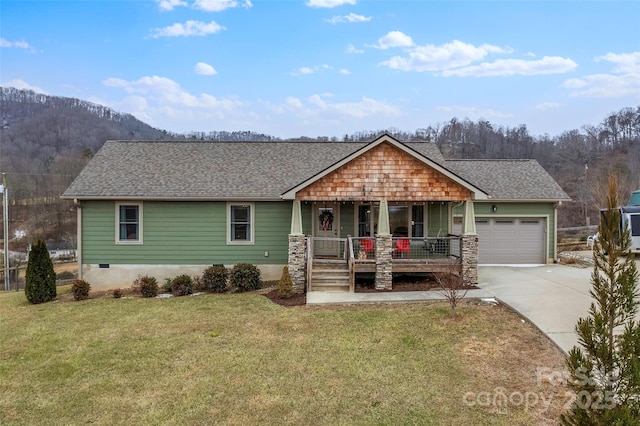 view of front of house featuring a garage, covered porch, and a front yard