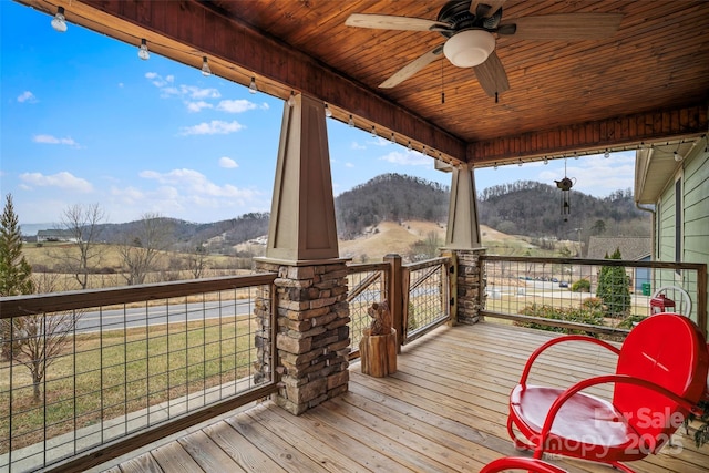 wooden terrace with a rural view, a mountain view, and ceiling fan