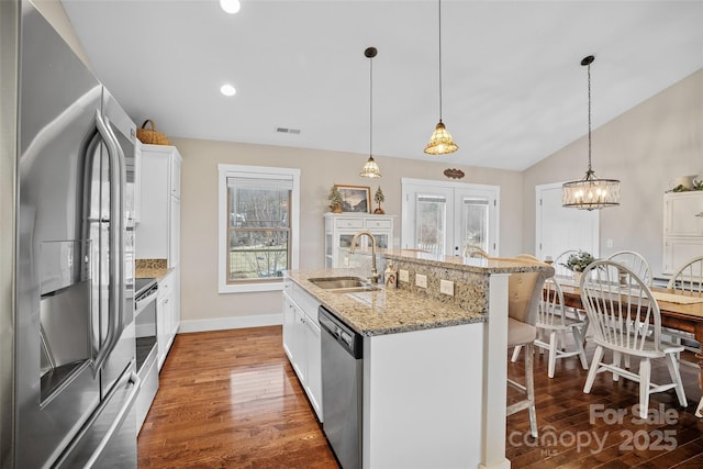 kitchen featuring sink, a breakfast bar area, white cabinetry, a center island with sink, and appliances with stainless steel finishes