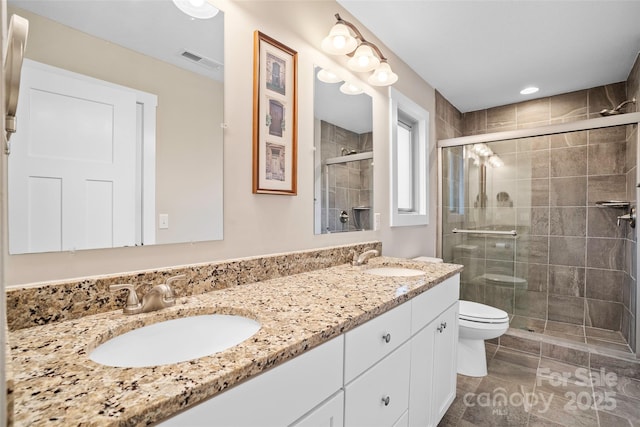 bathroom with vanity, a shower with shower door, tile patterned floors, and toilet