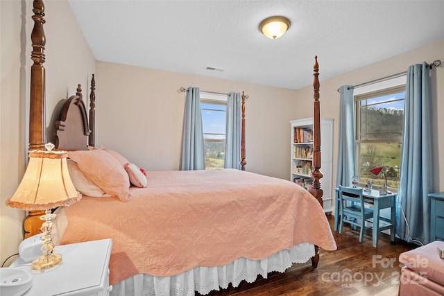 bedroom featuring multiple windows and dark hardwood / wood-style floors