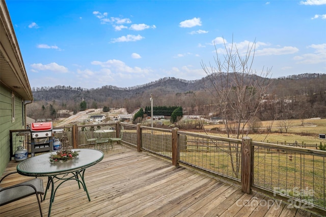 wooden deck featuring a mountain view and a grill