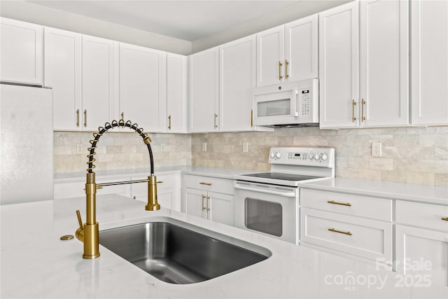 kitchen with white cabinetry, sink, backsplash, and white appliances