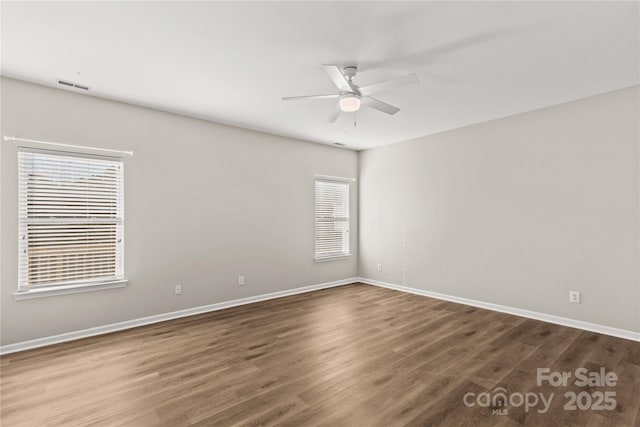 empty room featuring hardwood / wood-style flooring, ceiling fan, and a healthy amount of sunlight