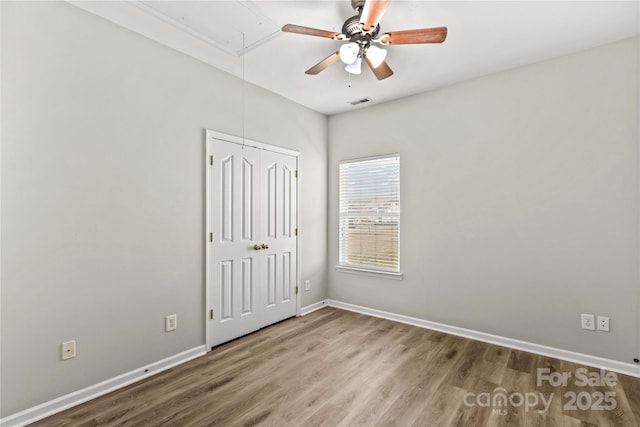 unfurnished bedroom with ceiling fan, hardwood / wood-style floors, and a closet