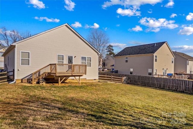 rear view of house featuring a lawn and a deck