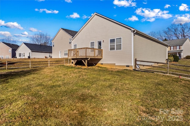 back of property with a deck and a lawn