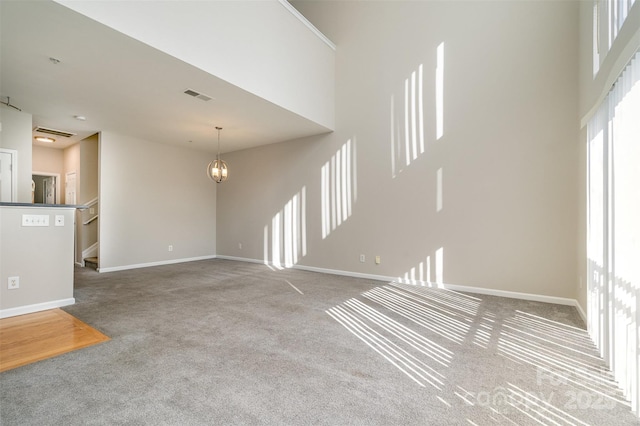 unfurnished living room with light carpet and a notable chandelier