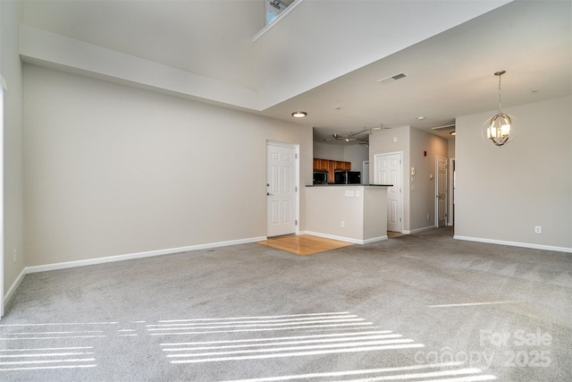 unfurnished living room with light carpet and an inviting chandelier