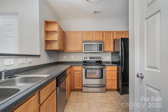 kitchen with light tile patterned floors, appliances with stainless steel finishes, and sink