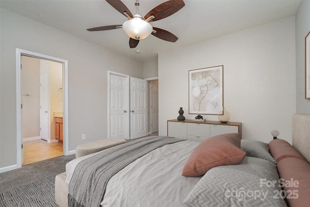 carpeted bedroom featuring ceiling fan and ensuite bathroom