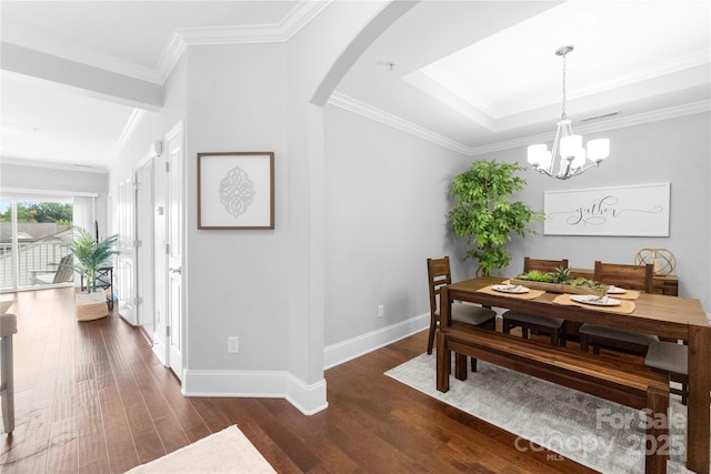 dining room with crown molding, dark hardwood / wood-style flooring, and a notable chandelier