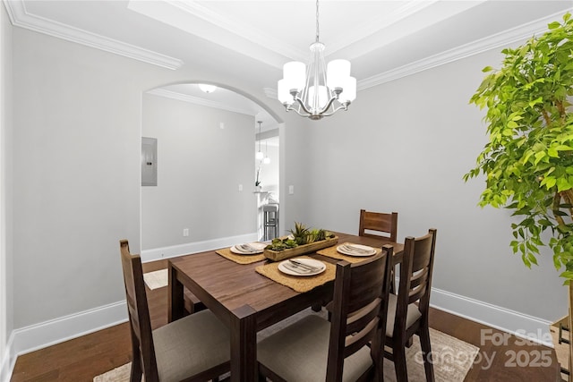 dining room with electric panel, a notable chandelier, a tray ceiling, ornamental molding, and dark hardwood / wood-style flooring