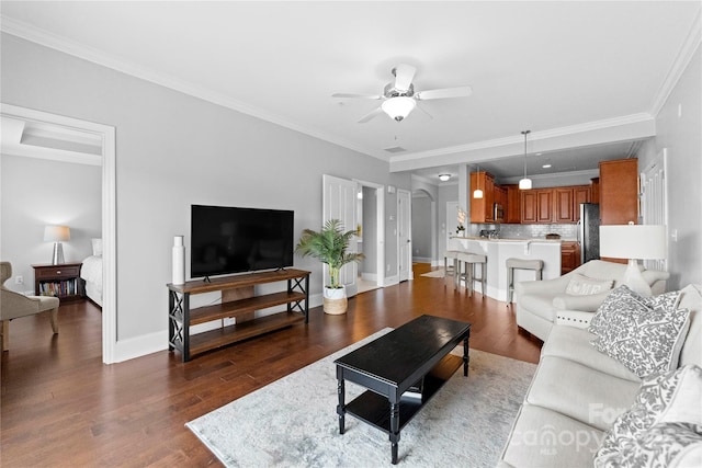 living room with dark hardwood / wood-style flooring, crown molding, and ceiling fan