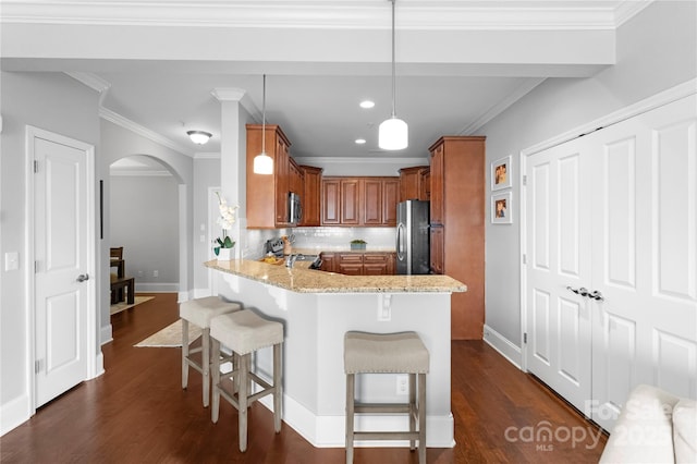 kitchen with decorative light fixtures, a kitchen bar, kitchen peninsula, stainless steel appliances, and light stone countertops