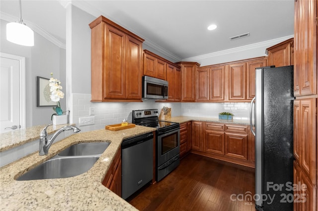 kitchen with stainless steel appliances, light stone countertops, sink, and decorative light fixtures