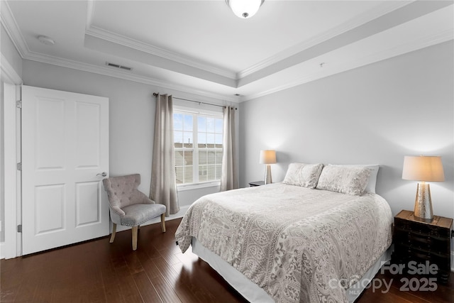 bedroom featuring a tray ceiling, ornamental molding, and dark hardwood / wood-style floors