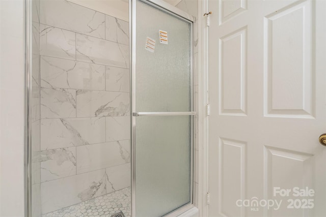 bathroom featuring a shower with door