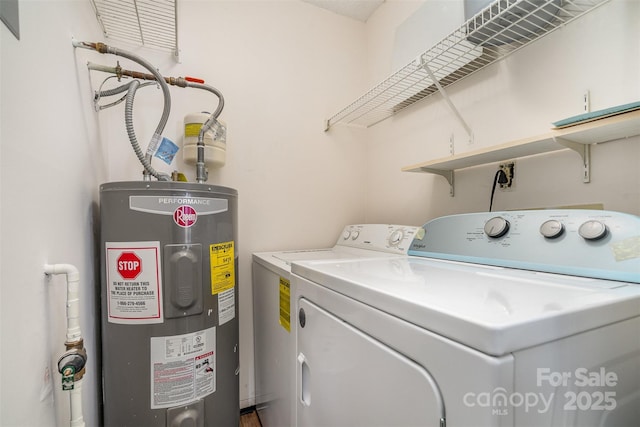 clothes washing area featuring washing machine and dryer and electric water heater