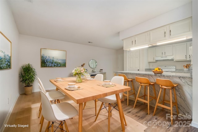 dining room featuring light wood-type flooring and baseboards