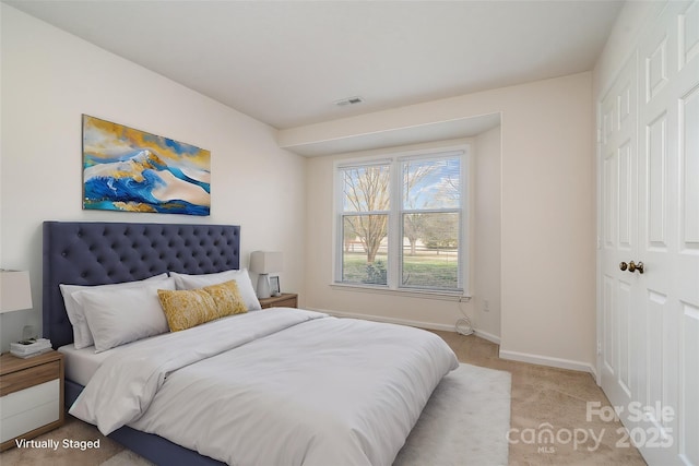 bedroom with light carpet, visible vents, and baseboards