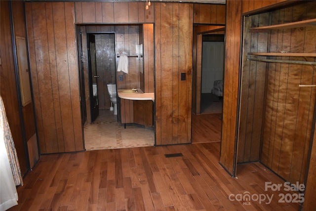 hallway with dark hardwood / wood-style flooring and wood walls