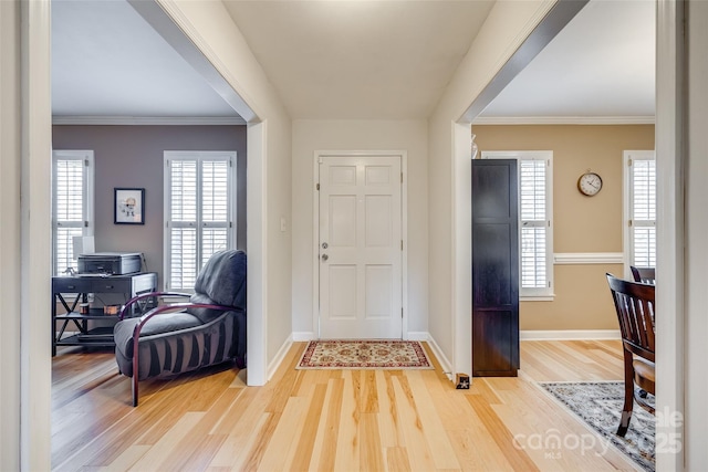 foyer with crown molding and light wood-type flooring