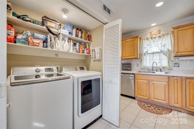 laundry area with light tile patterned flooring, washer and dryer, sink, and crown molding